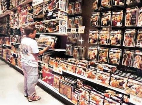 A child browsing shelves of toys in a toy store.